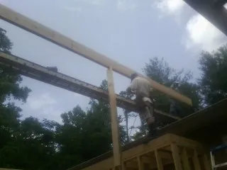 Carpenter setting a ridge beam over a new addition frame — Ice Dam Removal by Roofing Brothers in Eastlake Weir