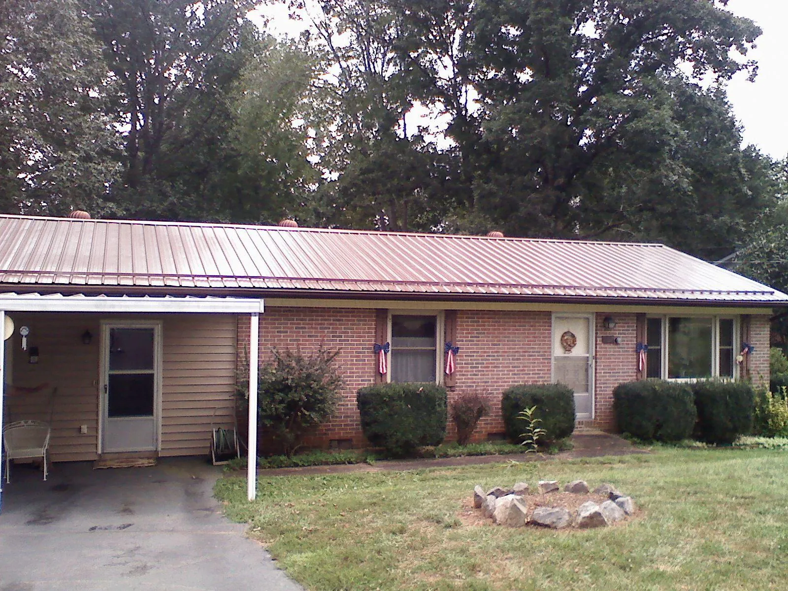 Bronze metal roof and carport on a brick ranch home — Roof Repair work by our crew in Eastlake Weir